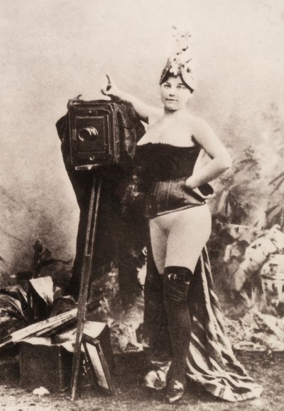 Ritratto di una donna parzialmente nuda appoggiata a una macchina fotografica antica da Unknown photographer
