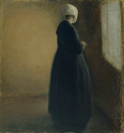 Una vecchia donna in piedi vicino a una finestra da Vilhelm Hammershøi
