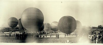 Mongolfiere in un campo a South St. Louis pronte per il lancio; una è già in cielo in lontananza da W.C. Persons