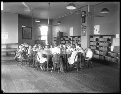 Bambini ascoltano una donna nella sala di lettura di una filiale non identificata della Queens Borough Public Library da William Davis Hassler