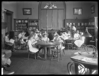 Bambini che leggono nella sala di lettura di una filiale non identificata della Biblioteca Pubblica del Queens Borough, c.1910 da William Davis Hassler