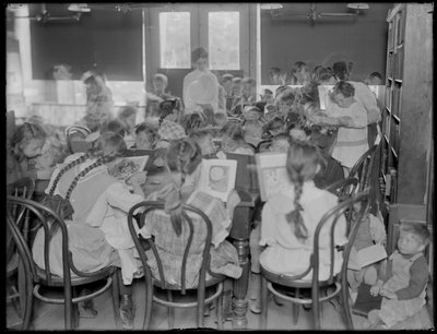 Bambini che leggono nella sala di lettura di una filiale non identificata della Biblioteca Pubblica del Queens, c.1910 da William Davis Hassler