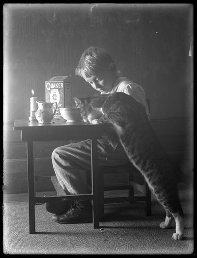 William Gray Hassler e Reddy il gatto, che mangiano cereali Quaker puffed rice, c.1912 da William Davis Hassler