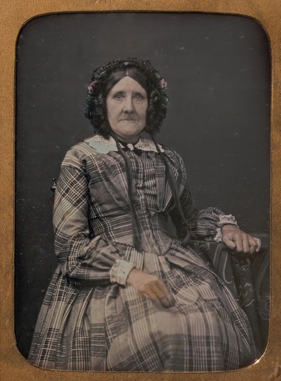 Anziana donna seduta con vestito a quadri e cappellino da William Hardy Kent