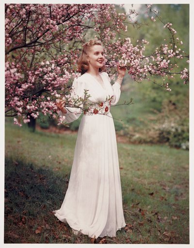 Donna che modella un vestito vicino ai fiori, c. 1940 da Frederick (attr. to) Barnard