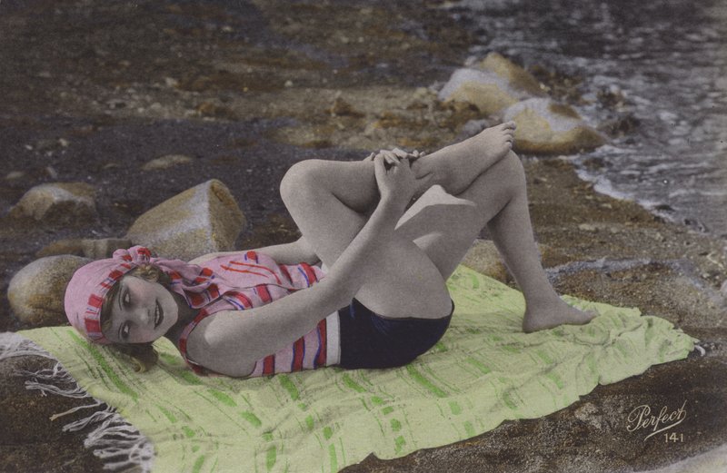 Ragazza sdraiata su un asciugamano sulla spiaggia da English Photographer