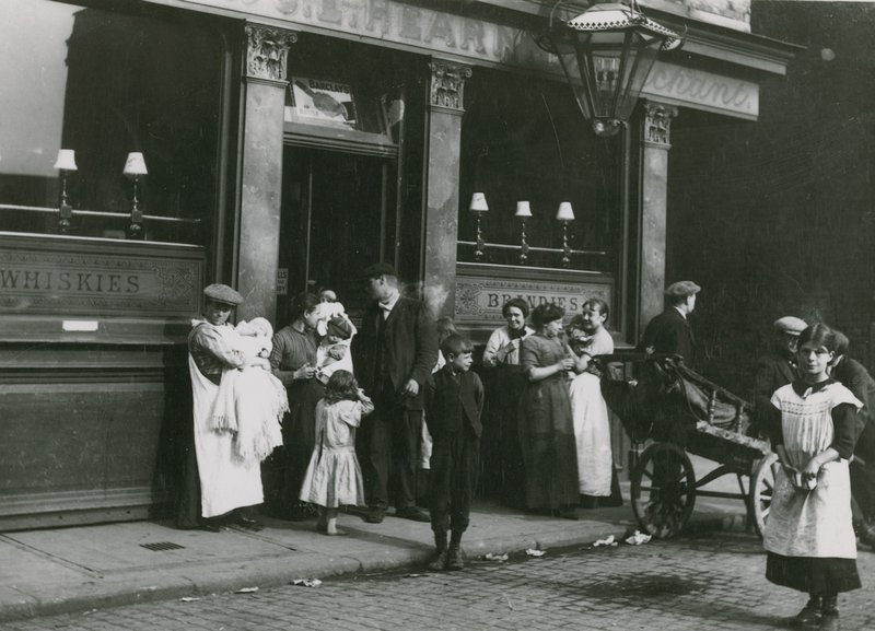 Uomini, donne e bambini fuori da una taverna di Londra da English Photographer