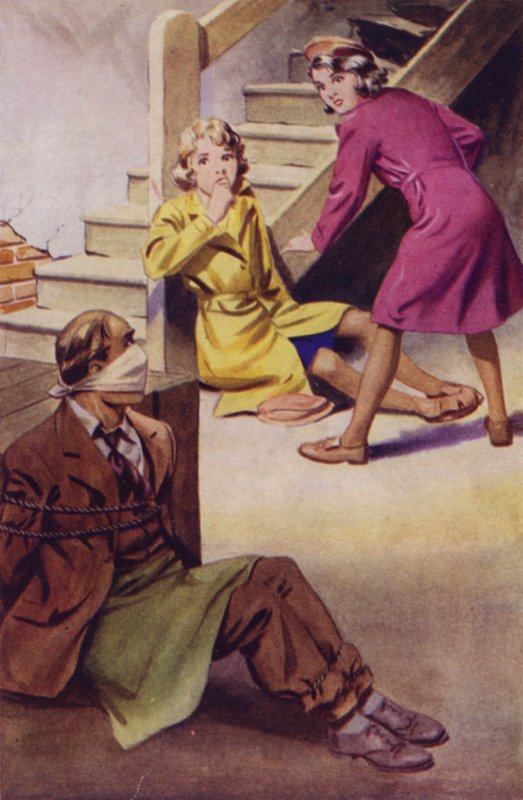 Un uomo legato, imbavagliato e seduto sul pavimento mentre due ragazze lo osservano da English School