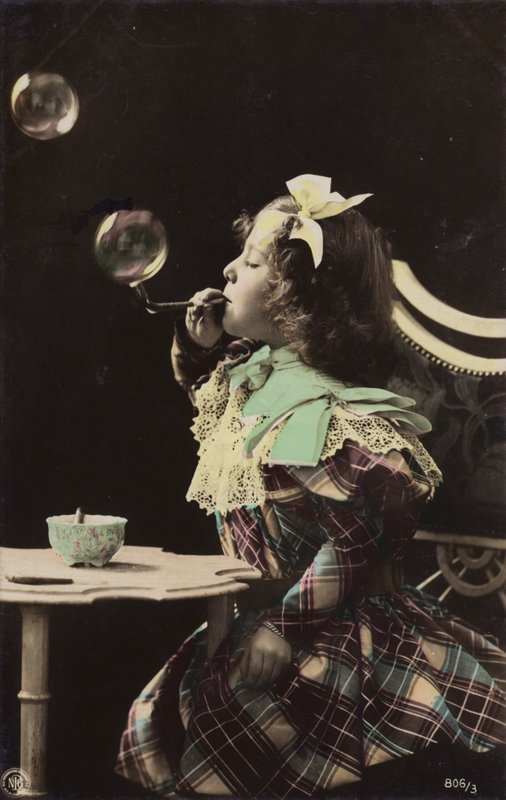 Una bambina che soffia bolle da una pipa da French Photographer
