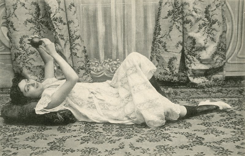 Ragazza sdraiata sul pavimento, che tiene una palla sopra la testa da French Photographer