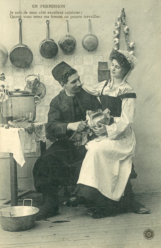 Serva seduta sulle ginocchia di un uomo in cucina da French Photographer