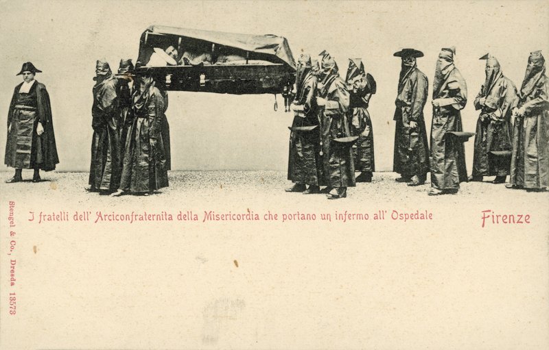 Fratelli della Compagnia della Misericordia che trasportano un malato all