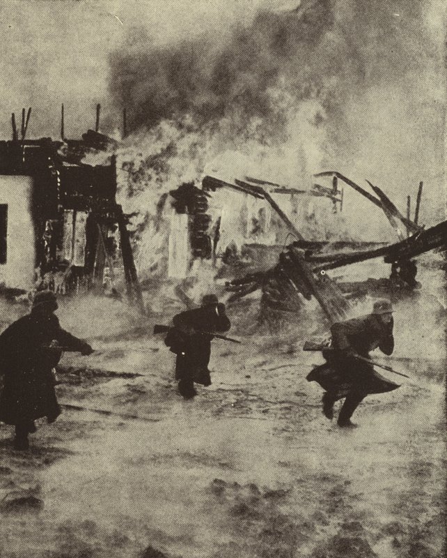 Soldati tedeschi avanzano tra le rovine in fiamme di Rotterdam dopo il bombardamento della Luftwaffe, Seconda Guerra Mondiale, maggio 1940 da Photographer German