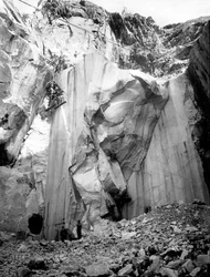 Cavatori al lavoro lungo una parete ripida di una cava di marmo nelle Alpi Apuane, Toscana