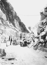 Escavatori al lavoro in una cava di marmo nelle Alpi Apuane, Toscana