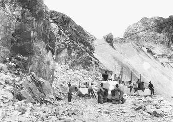 Scavatori al lavoro in una cava di marmo nelle Alpi Apuane, Toscana. Alcuni di loro sono seduti su blocchi di marmo già squadrati
