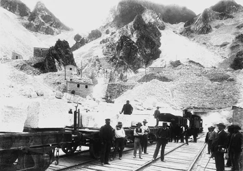 Cavatori davanti a un convoglio ferroviario carico di blocchi di marmo a Ravaccione, nelle Alpi Apuane