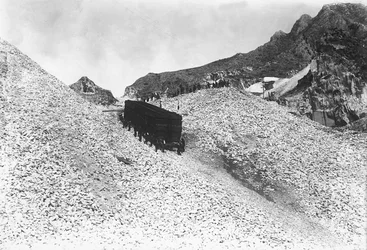 Trasporto di un enorme convoglio di marmo lungo una strada presso una cava nelle Alpi Apuane, Toscana