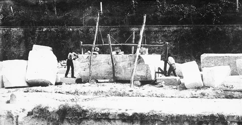 Due macchine per squadrare il marmo al lavoro in una cava nelle Alpi Apuane, Toscana