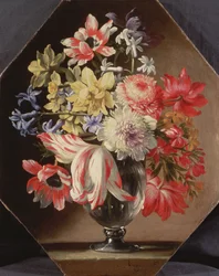 Vaso di vetro con fiori su un bordo di pietra contenente tulipani, crisantemi, rose e campanule