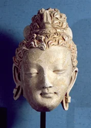 Testa di un Buddha sorridente, stile greco-buddista, da Hadda, I-IV secolo