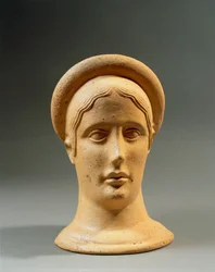 Primo piano di una testa votiva femminile in bronzo con cappello, civiltà italica, IV-III secolo a.C.