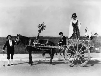 Villa Rosa Maltoni Mussolini: ritratto di un gruppo di adolescenti in costumi tradizionali siciliani, posando su un tipico carro della regione (foto in bianco e nero)