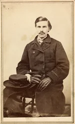 Uomo non identificato con cappotto, cappello e guanti