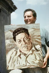 Il pittore e scrittore italiano Carlo Levi (1902-1975) con in mano una delle sue opere, un ritratto del sindacalista Giuseppe di Vittorio (foto)