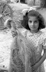 LAVORAZIONE DELLA CANAPA, RAGAZZA CON UN FASCIO DI FIBRE