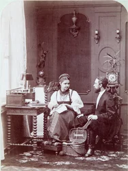 Composizione alla russa: interno di un alloggio russo con uomo e donna che ricamano e vestiti in costume tradizionale. Fotografia di Andrei Osipovich Karelin (1837-1906), anni 1870-1880. Museo Statale di Storia, Mosca