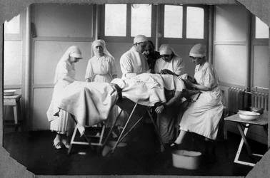 Prima Guerra Mondiale 1914-1918: medici e infermieri della Croce Rossa (Therese Pavillou?) curano le ferite di un soldato addormentato con cloroformio nel campo di Couville nella Manche, Bassa Normandia, Francia. Fotografia anonima