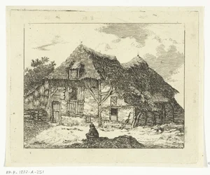 Uomo seduto su una collinetta davanti a una casa a Staphorst