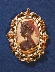 Cammeo con il profilo della dea Diana, con un orecchino di perla, la cornice dorata decorata con pietre semipreziose e smalto bianco e blu