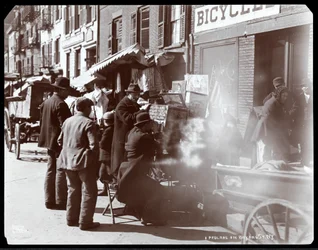 Veduta di venditori ambulanti, incluso uno che mostra vedute fotografiche di luoghi esotici in una viewbox, su Bayard Street, New York, 1898