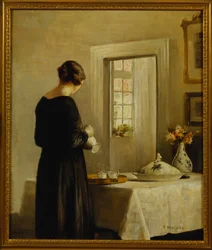 Un interno con una donna a un tavolo