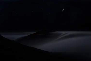 Strada di montagna in una notte nebbiosa