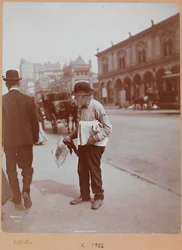 Un uomo sul marciapiede di Broadway tra la 34th St. e la 35th St. che tiene il giornale The Evening Telegram