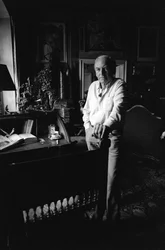Jiri Mucha in piedi vicino alla sua scrivania nella sua casa a Hradcany, Praga