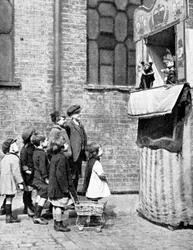 Bambini che guardano uno spettacolo di Punch e Judy in una strada di Londra