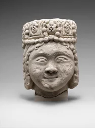 Testa di una figura con copricapo di perline