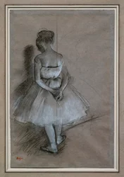 Ballerina in piedi, mani incrociate dietro la schiena