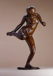 Nudo che guarda la pianta del piede destro