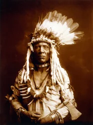 Weasel Tail, Piegan, con un tomahawk, c. 1900, foto di Edward S. Curtis