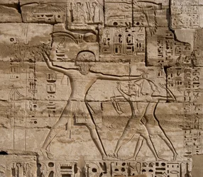 Antichità egiziana: dettaglio dei rilievi che celebrano le vittorie del faraone sui popoli del mare. Tempio funerario di Ramses III (1187-1156 a.C.). Luxor, Medinet Habu, Egitto