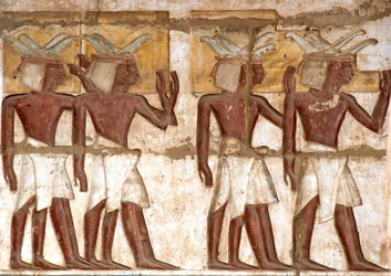 Antichità egizia: primo cortile, dettaglio di rilievi dipinti che rappresentano un gruppo di Nubiani che portano offerte al faraone. Tempio funerario di Ramses III. Luxor, Medinet Habou, Egitto