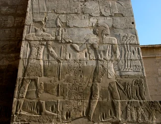 Antichità egiziane: tempio funerario di Ramses III (1187-1156 a.C.). Bassorilievo che rappresenta il faraone che riceve le insegne del potere dalle mani di Amon. Luxor, Medinet Habu, Egitto