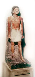 Statua di un uomo in piedi con uno shenti bianco