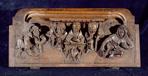 Una misericordia che raffigura un accademico seduto a una scrivania che ammonisce un penitente inginocchiato, Cappella del New College, Oxford, fine XIV secolo