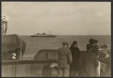[Gruppo di persone sul ponte di una nave che guardano un